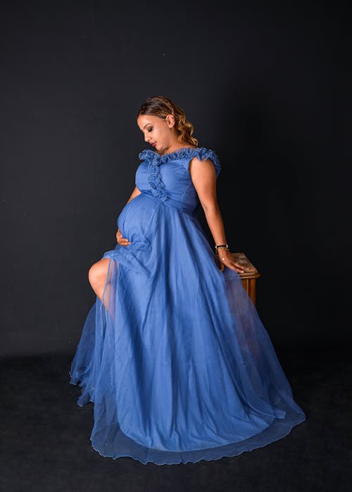 A Pregnant Woman in a Dress Posing in Studio 