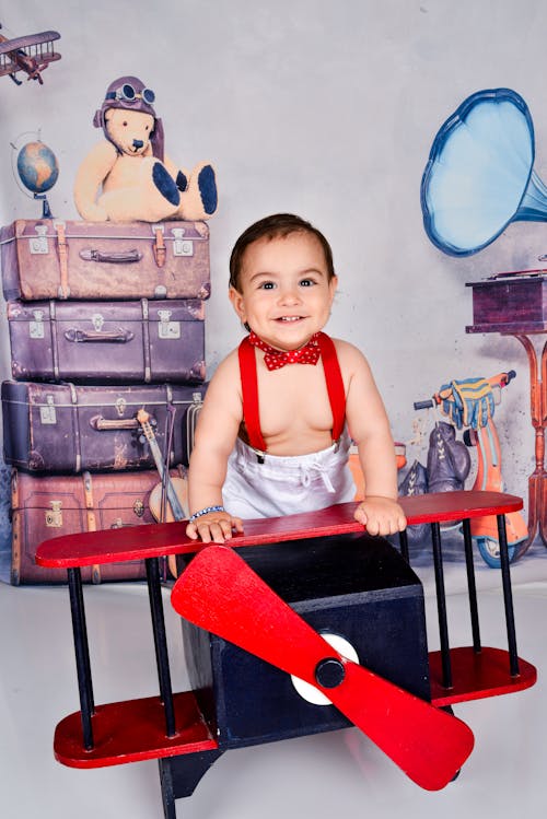 A Baby on a Photoshoot Sitting in Toy Plane