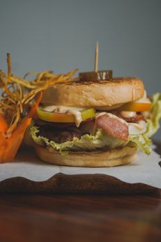 Close-up of a gourmet burger with tasty toppings on a wooden board.
