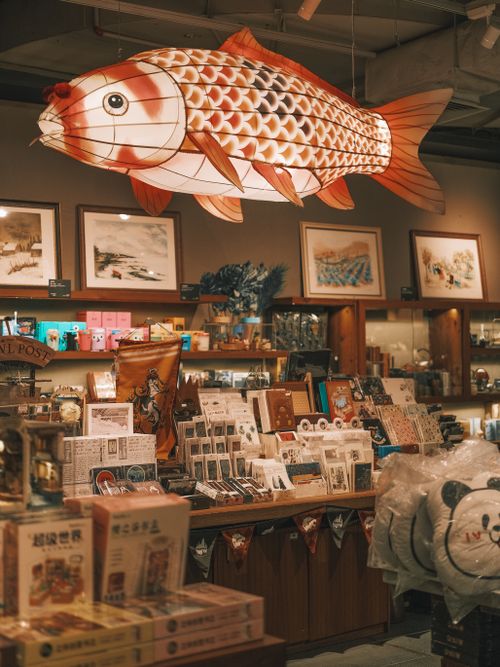 Free Interior of a unique bookstore featuring a large hanging fish decoration and various art pieces. Stock Photo