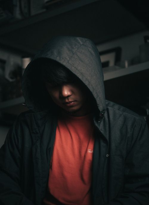 Free A moody portrait of a man wearing a hooded jacket with a dark, atmospheric focus. Stock Photo