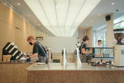 Baristas preparing coffee in a modern café, showcasing a stylish interior and professional atmosphere.