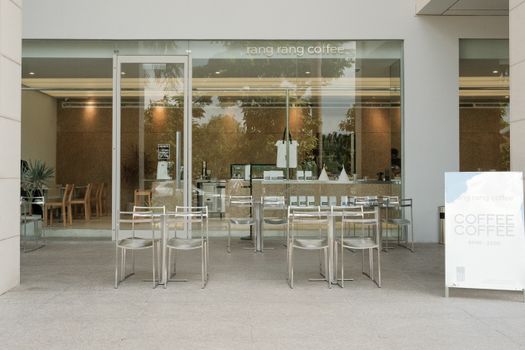 A modern café with outdoor seating, minimalist decor, and inviting ambiance.