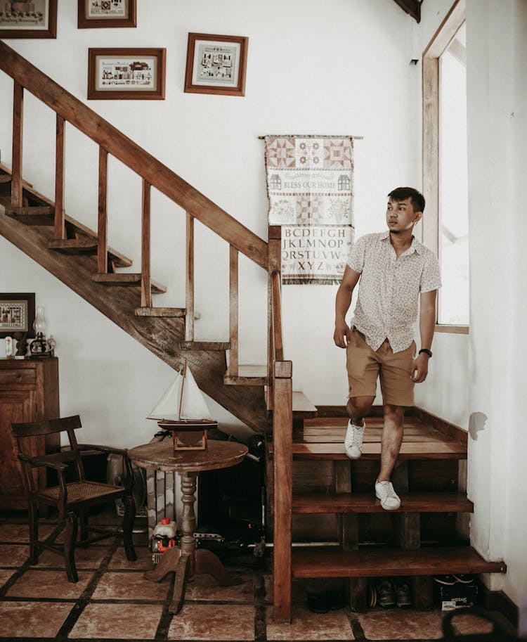 Man Walking Downstairs In House