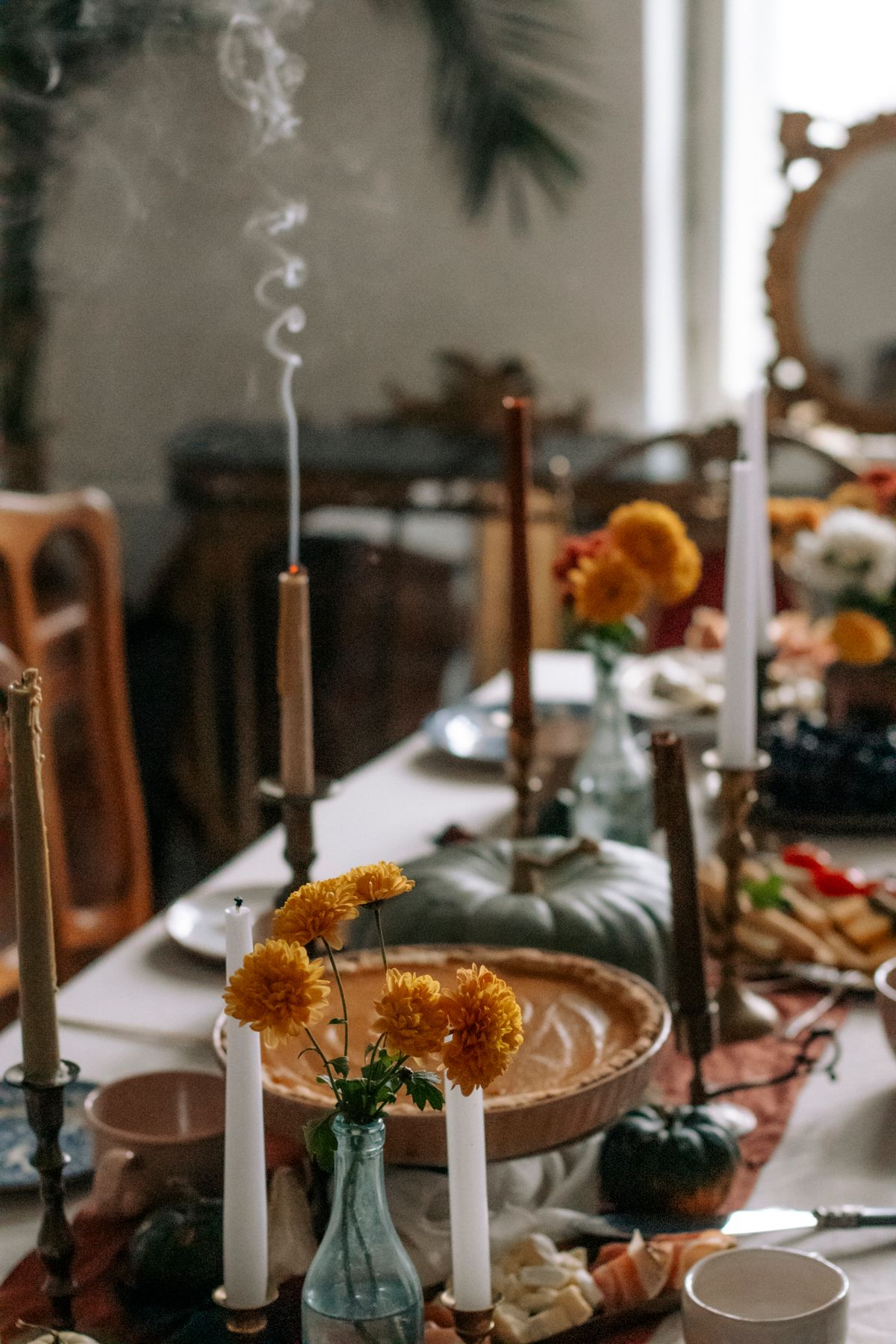 Thanksgiving table setting ideas with a warm and inviting autumn table setting featuring pumpkins, candles, and fall flowers