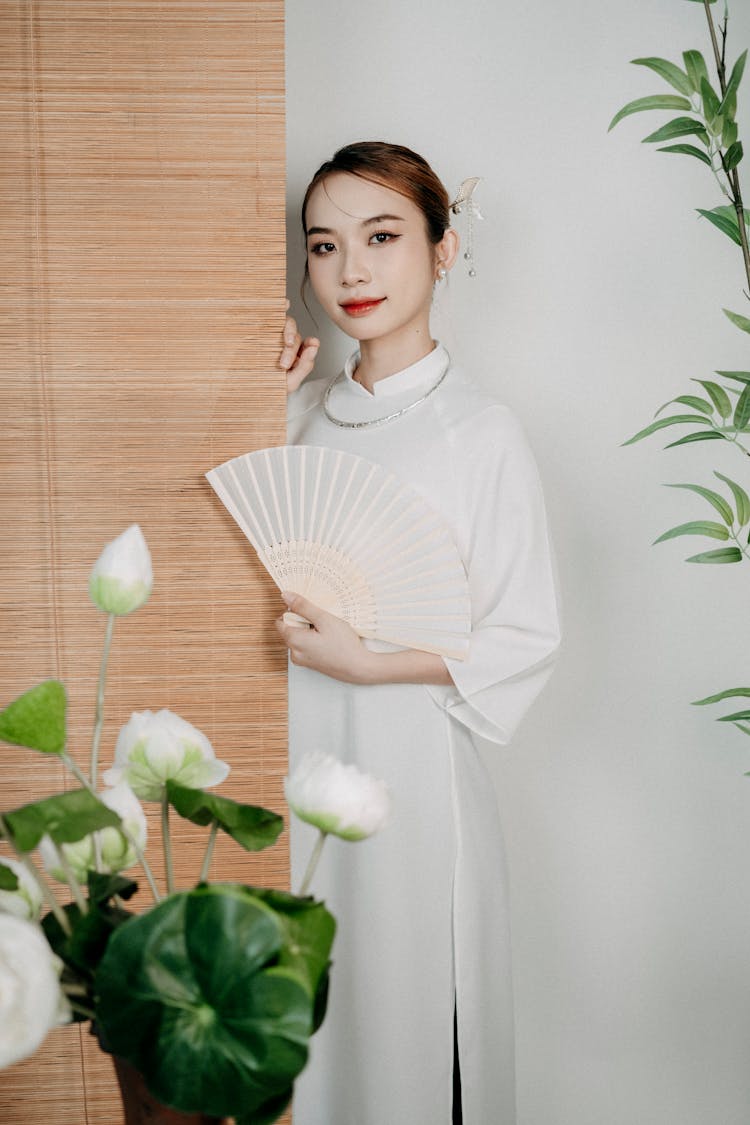 Woman Standing In Traditional Clothing And With Fan