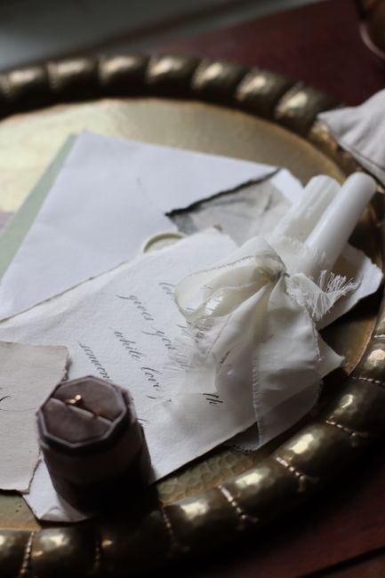 A vintage-inspired composition featuring candles, letters, and antique accents on a decorative tray.
