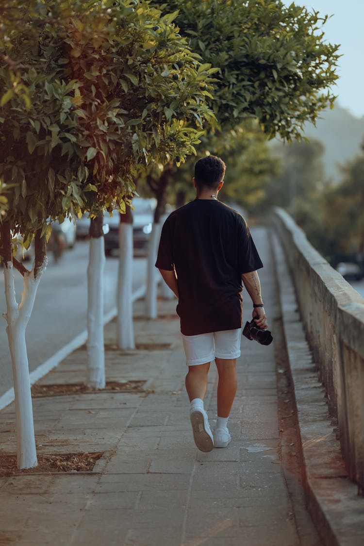 Man Walking Wiht A Camera In His Hand