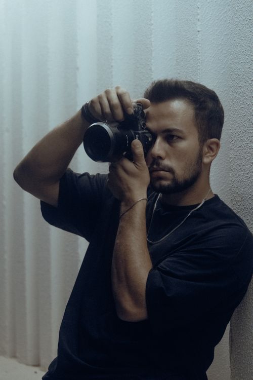 Free A man captures a moment with a camera in an indoor setting, showcasing photography skills. Stock Photo