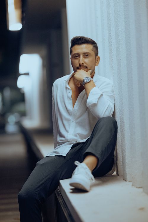 Free Portrait of a man in a white shirt posing confidently in an urban environment. Stock Photo