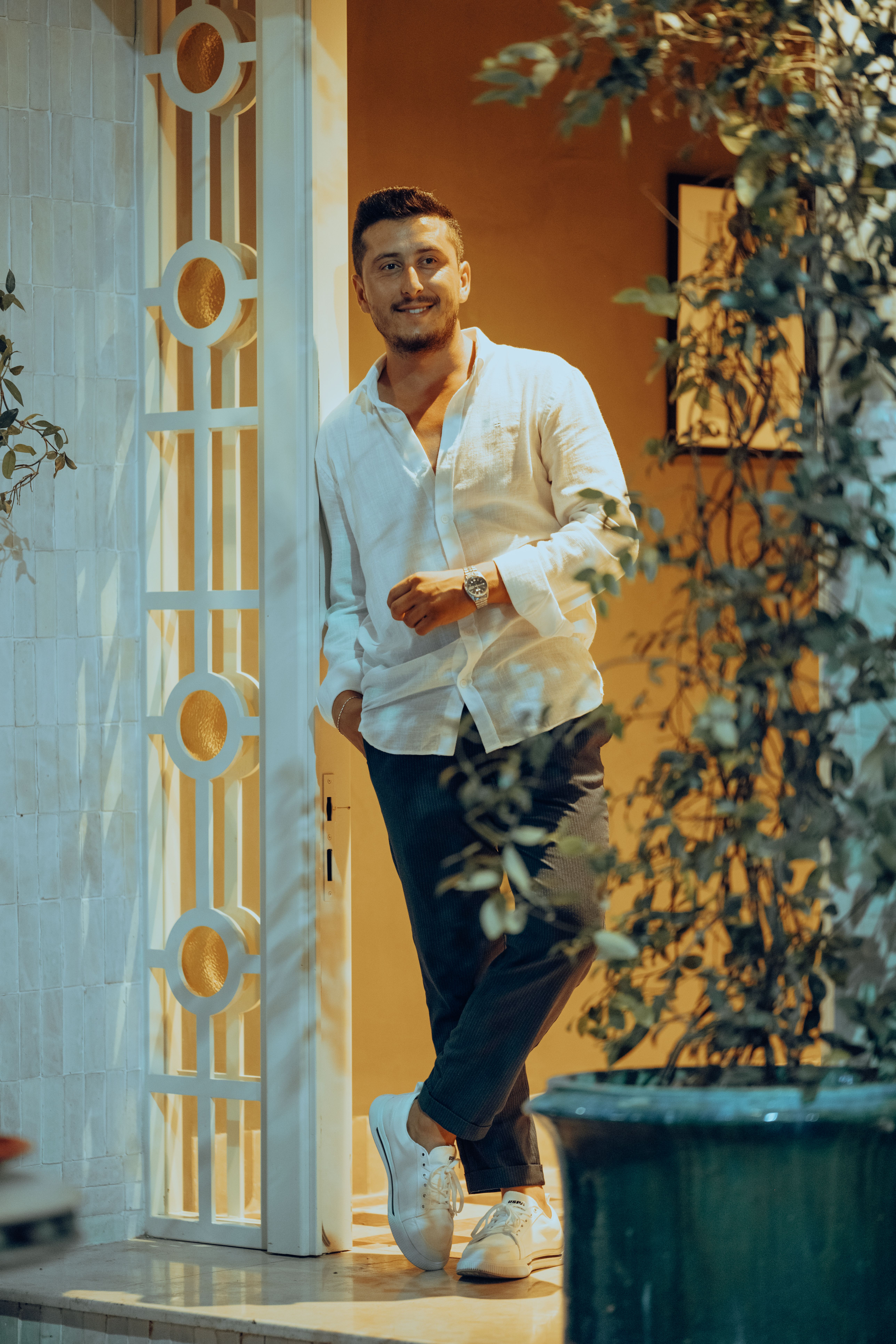 Man in a White Shirt and Pants Leaning against the Door · Free Stock Photo