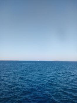 Peaceful scene of the open sea with a blue sky in Kupang, Indonesia.