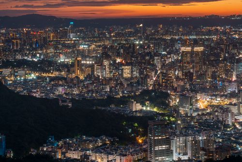 Free Aerial view of Taipei's illuminated skyline during a vibrant sunset. Stock Photo