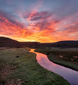 Vibrant sunset sky reflecting on a winding river in scenic valley landscape in Tell, Wisconsin.