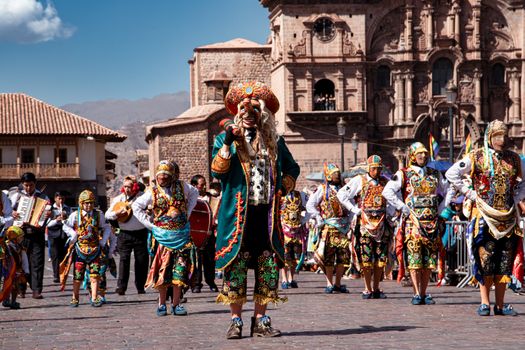 Colorful dancers in traditional costumes parade through Cusco, showcasing rich cultural heritage.