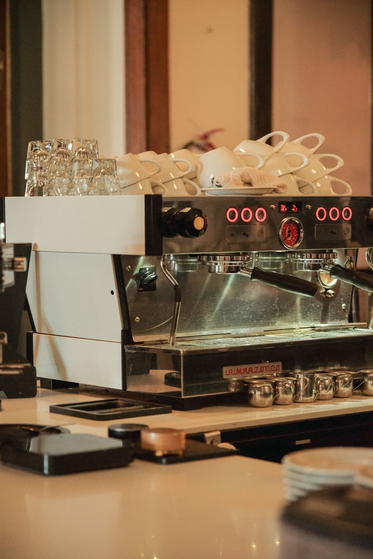 Espresso machine with stacked cups in a cafe setting, for illustration