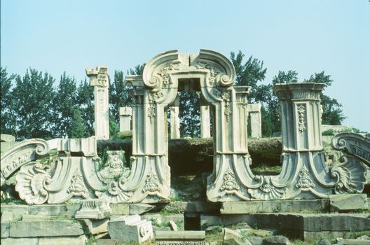 Intricate stone ruins of Yuanmingyuan Garden, Beijing under a clear sky.