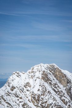 Stunning snowcapped mountain peak with blue sky in background, showcasing natural beauty.
