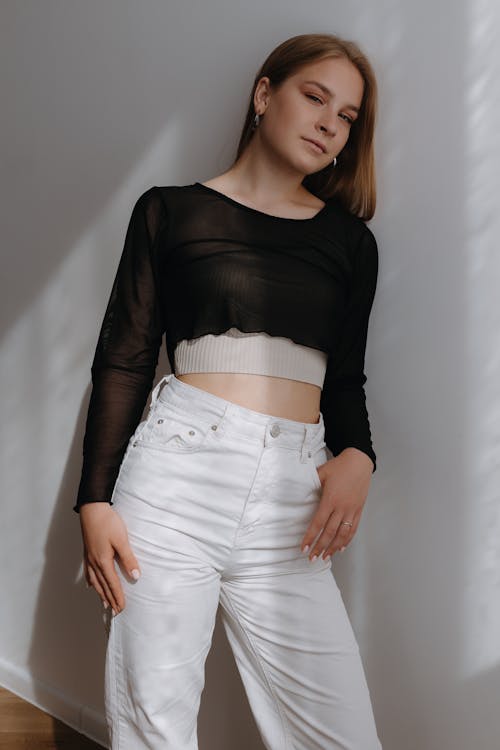 Young Woman Posing in Black See Through Top and White Jeans 