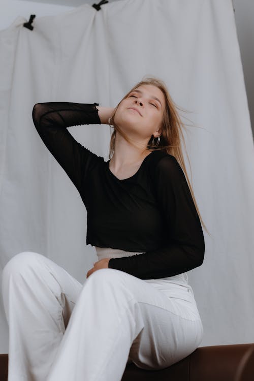 Blonde Woman Sitting and Posing with Eyes Closed