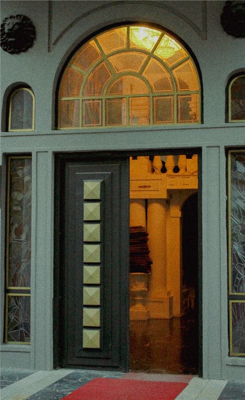 Free An inviting entrance with a stylish arched window, warm lighting, and geometric decorations. Stock Photo
