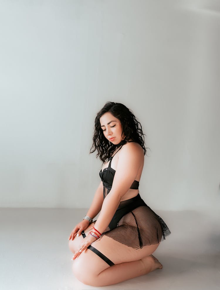 A Woman Kneeling In Lingerie