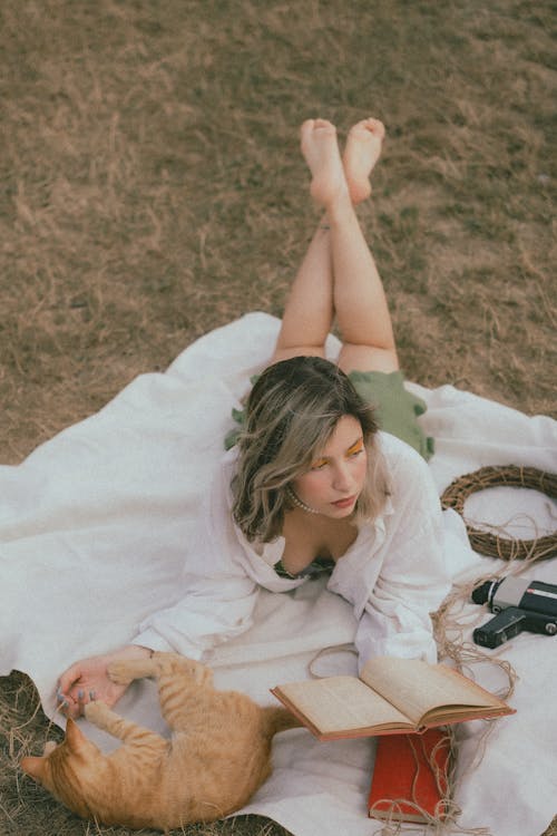 Woman Lying Down with Cat and Book on Picnic