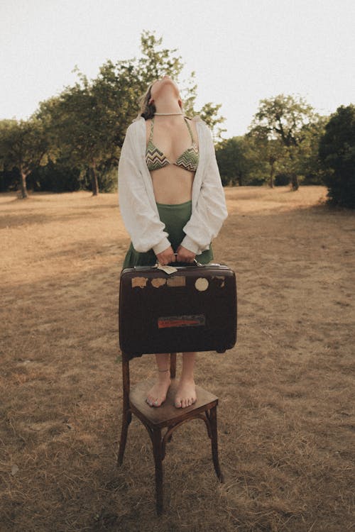 Woman Standing and Posing in Bra, Shirt and with Suitcase