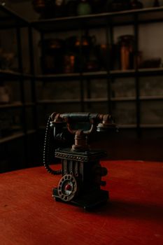 An antique rotary telephone sits in a dimly lit room, evoking a sense of nostalgia.