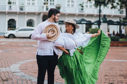 Free A joyful couple dressed in traditional clothing celebrating in a vibrant city street setting. Stock Photo