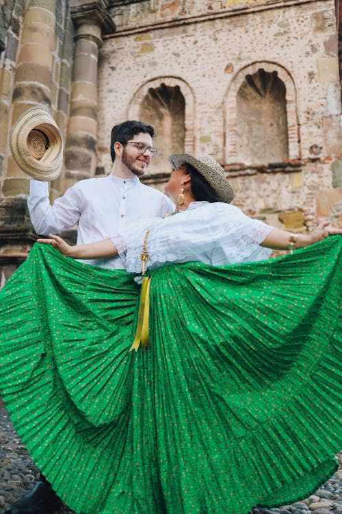Smiling Couple in Traditional Costumes Dancing in Old Town