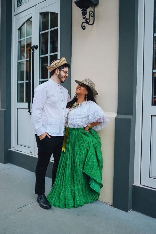Free A couple smiling and interacting in traditional attire, standing near a building in Panama. Stock Photo