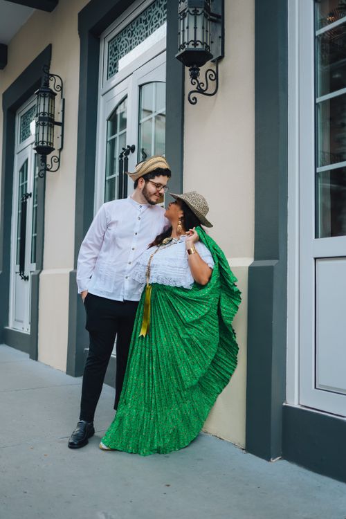 Free A couple dressed in traditional attire smiling and posing on a city street. Stock Photo