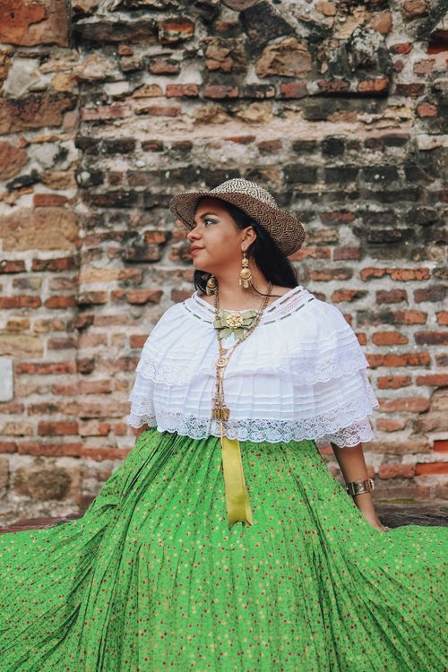Free Woman in traditional Panamanian clothing posing against a rustic brick wall. Stock Photo