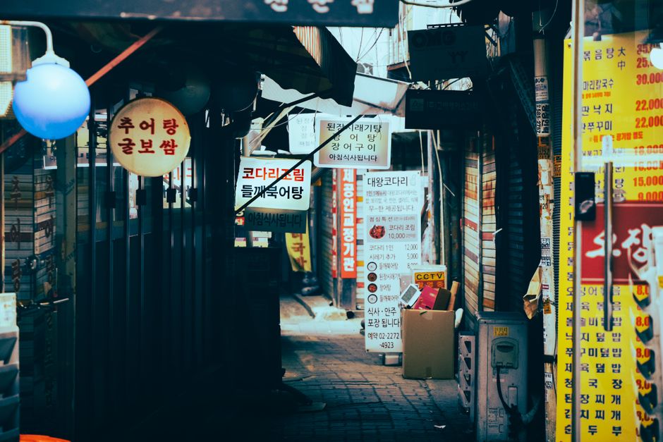 한글 간판과 노란 메뉴판이 가득한 좁은 골목길, 외국인 유입이 많은 로컬 상권의 현장