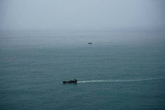A tranquil aerial shot of boats navigating through the serene ocean waters, offering a peaceful maritime scene.