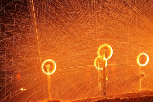 Time Lapse Photo of Sparks Shooting from Spinning Wheels 