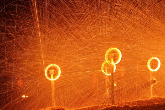 A captivating display of spinning light trails and sparks at night, creating a mesmerizing effect.