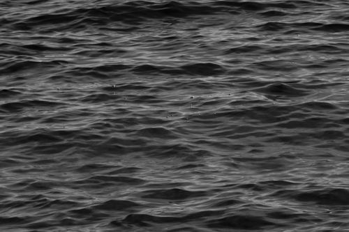 Free A serene black and white photo capturing gentle ripples on an ocean surface, creating a calming effect. Stock Photo