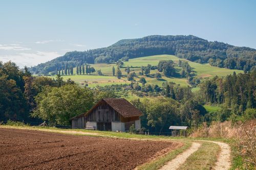 Free Discover a picturesque rural farmhouse with lush hills and scenic landscapes captured in daylight. Stock Photo