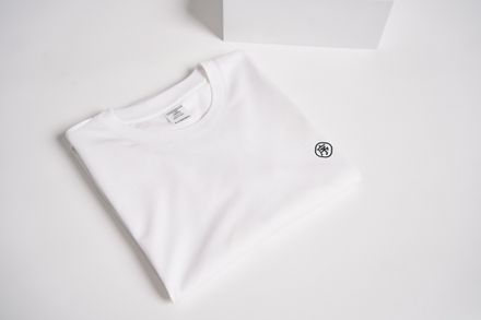 Folded ivory cotton tee on a pale surface — photo by dayong tien on Pexels