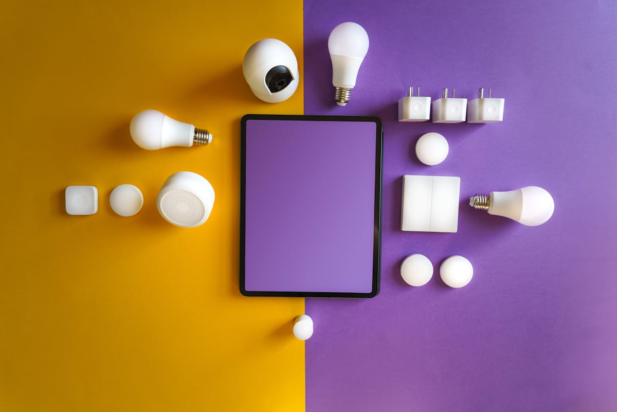 Smart home devices including smart plugs, bulbs, and a smartphone on a flat lay