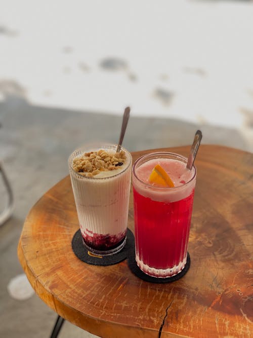 A Juice and Smoothie in Glasses on a Wooden Table 