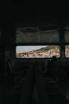 View of Çanakkale town from inside a ferry, capturing the scenic hills and sea.