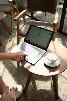A person uses a laptop at a café table in Istanbul, sipping coffee.