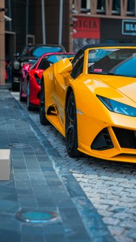 Yellow and red luxury sports cars parked on urban streets in Dubai's vibrant cityscape.