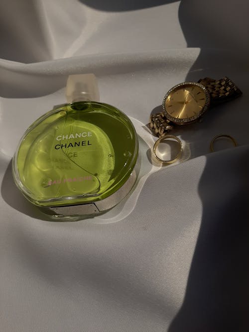 Close-up of Perfume Bottle and Golden Accessories