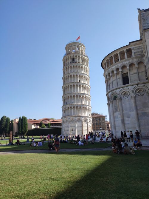 Free A vibrant day at the Leaning Tower of Pisa capturing tourists and architectural beauty. Stock Photo