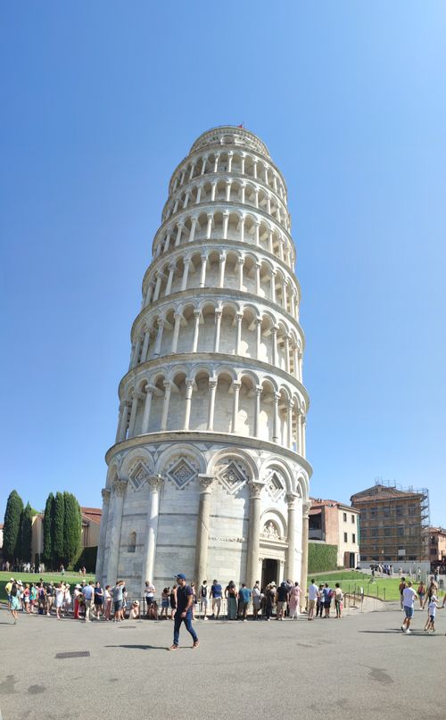 Free A sunny view of the iconic Leaning Tower of Pisa, with tourists enjoying the landmark. Stock Photo