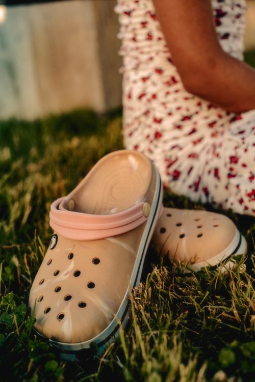 Free Close-up of casual beige clogs on grass, perfect for summer fashion. Stock Photo